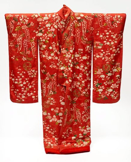 AGNSW collection Furisode uchikake (long-sleeve overcoat) with design of plum and cherry blossoms, peonies, chrysanthemums and wisteria on red figured silk satin ('rinzu') 19th century