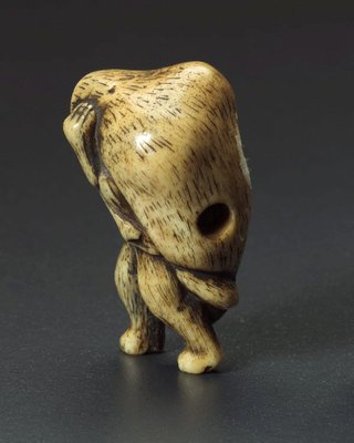 Alternate image of Netsuke in the form of a tanuki (raccoon dog) carrying a 'sake' bottle by 