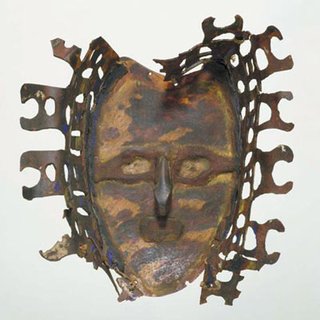 A mask of a human face carved from turtleshell and decorated with remnants of coloured paint. There is a carved fringe projecting from the front, attached with string and resin. Collected and presented to the Australian Museum by H Stockdale in 1898. © Australian Museum